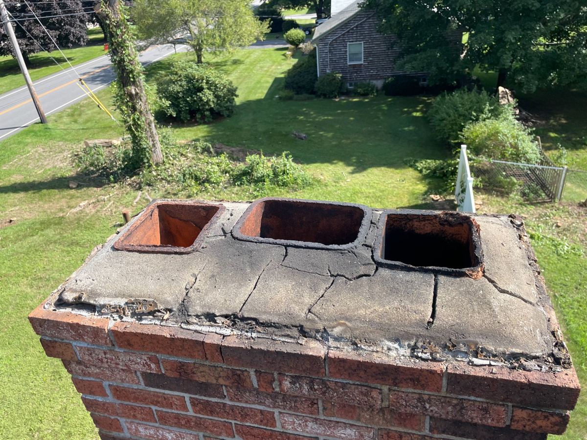 Cracked chimney crown before repair in Greater Boston