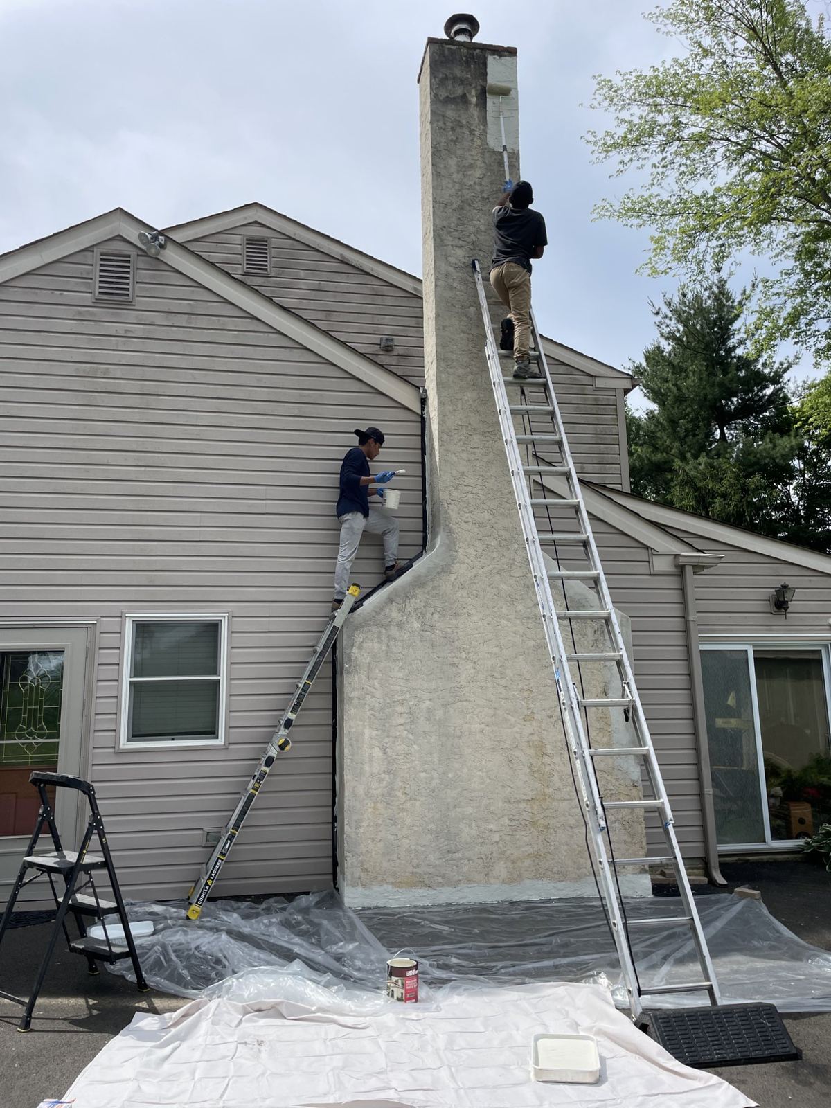 Mikey's Chimney team repairing chimney on ladders in Greater Boston